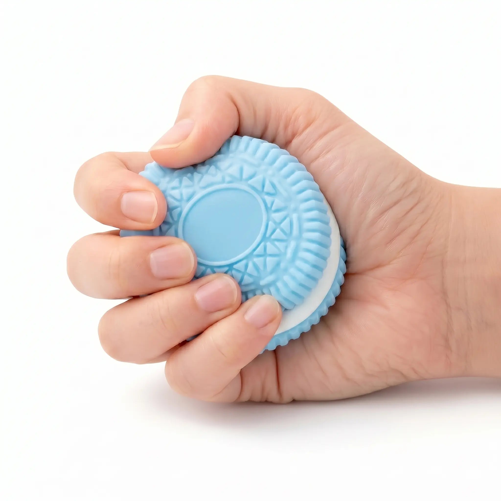 A hand squeezing a Blue Cookie showing its slow rising soft texture for stress relief.