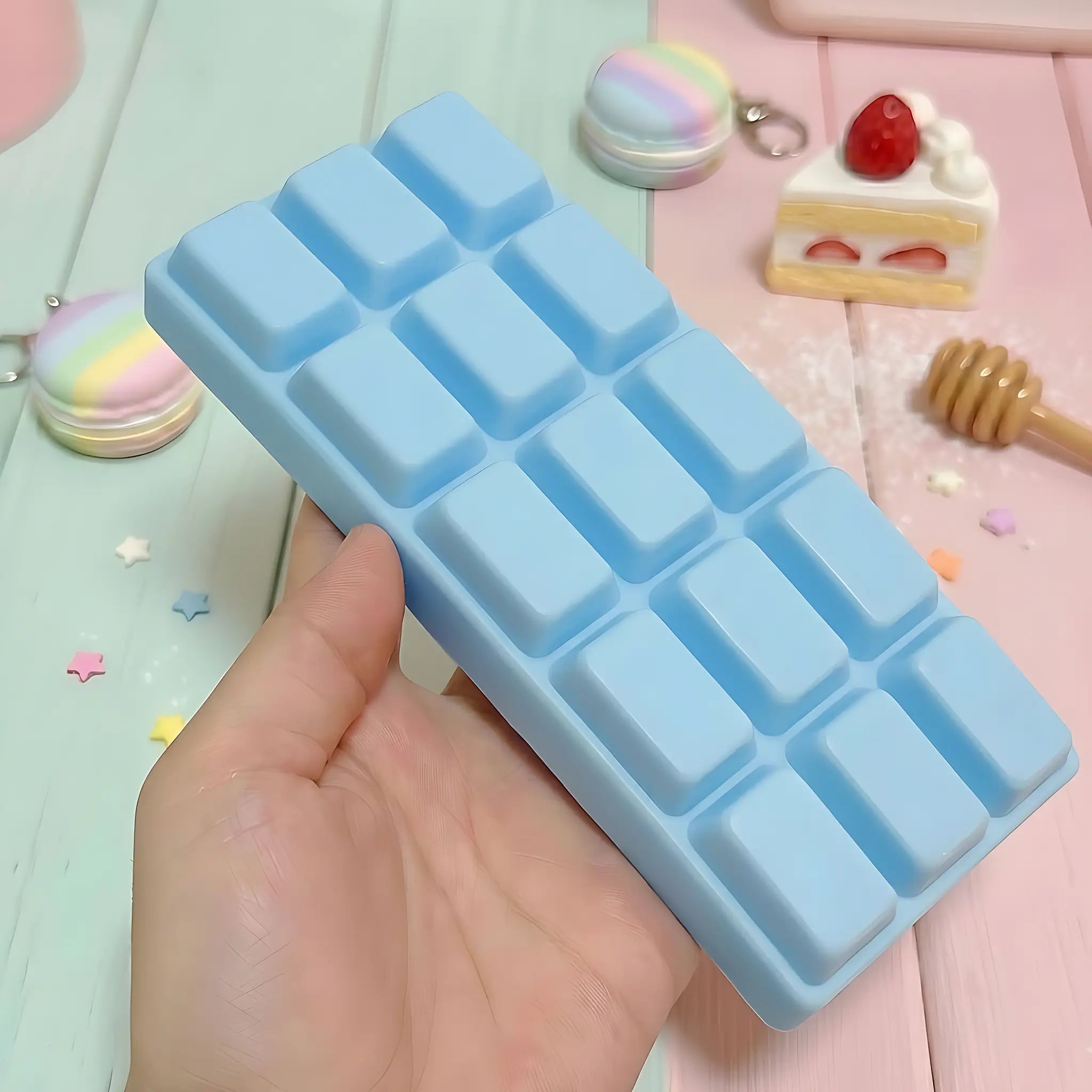 Blue chocolate bar squishy displayed on a light blue surface surrounded by wrapped candy and sweet accessories