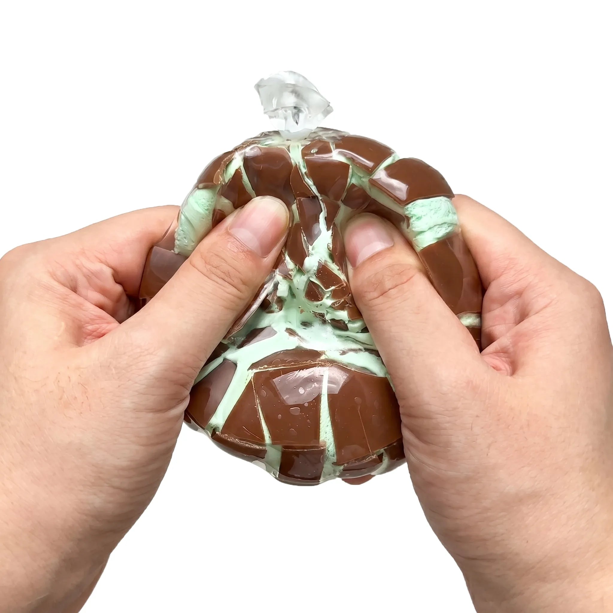 Two hands cracking and squeezing a mint chocolate wax stress ball revealing green inside by MimiSquishy