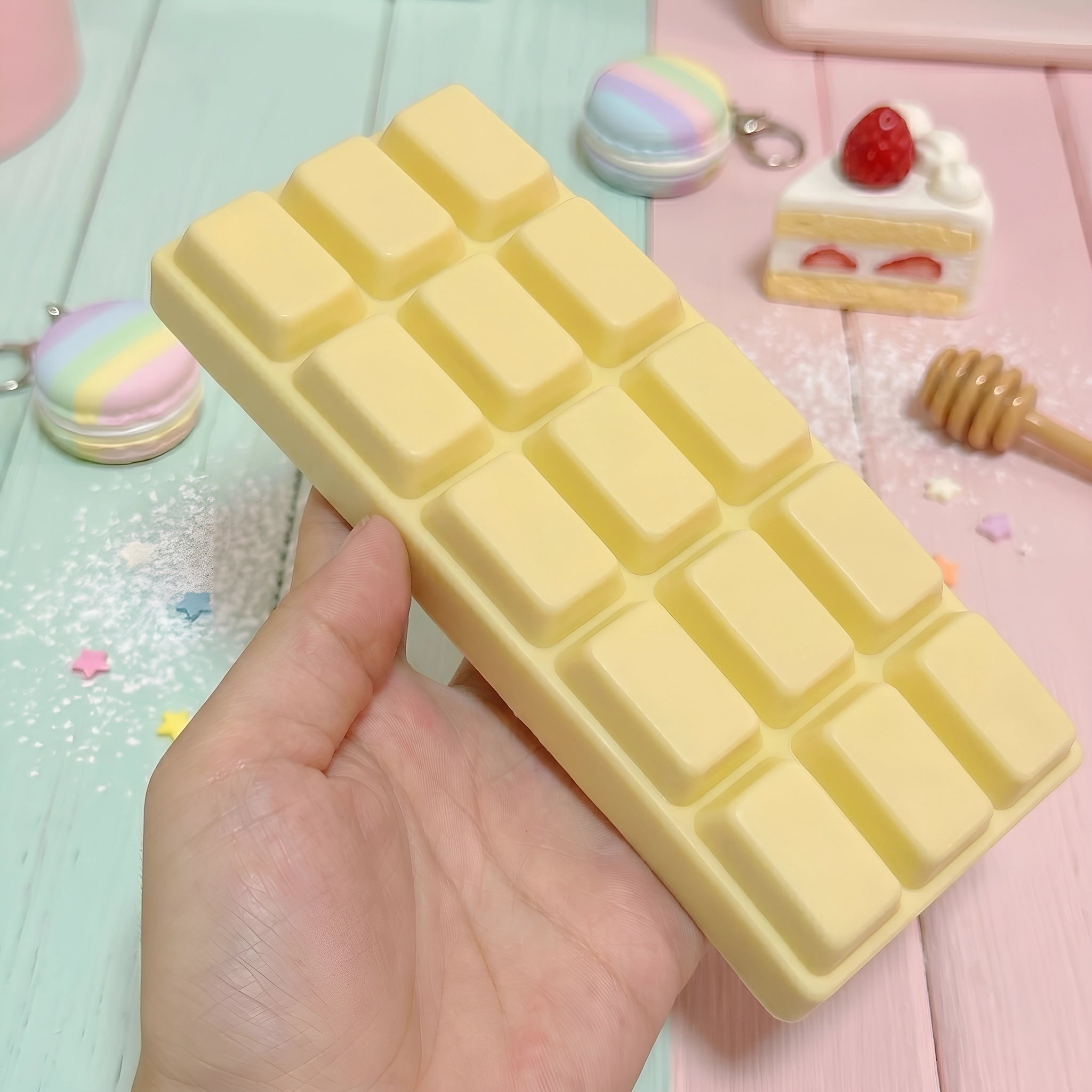 White chocolate bar squishy displayed on a warm wooden surface surrounded by sweet accessories
