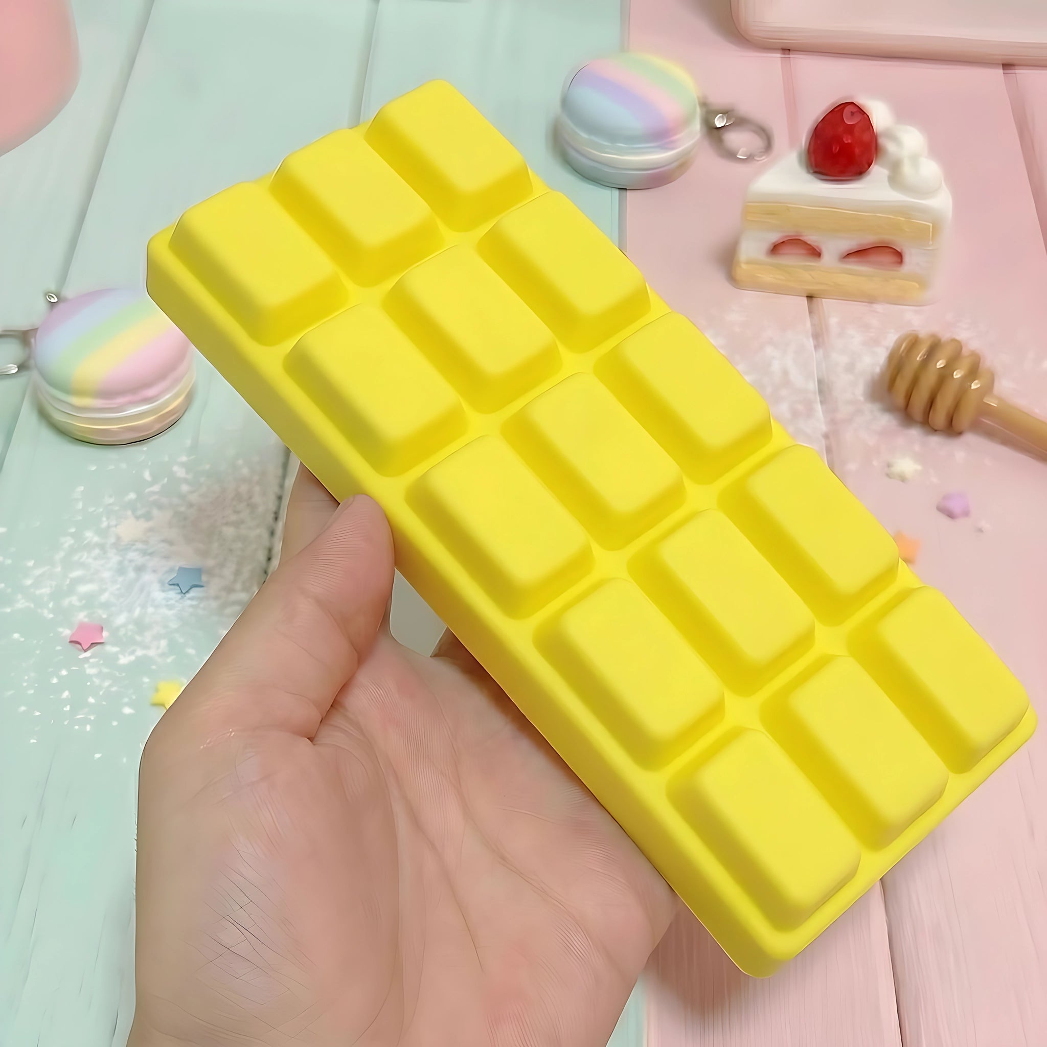 Yellow chocolate bar squishy displayed on a bright surface surrounded by sweet accessories