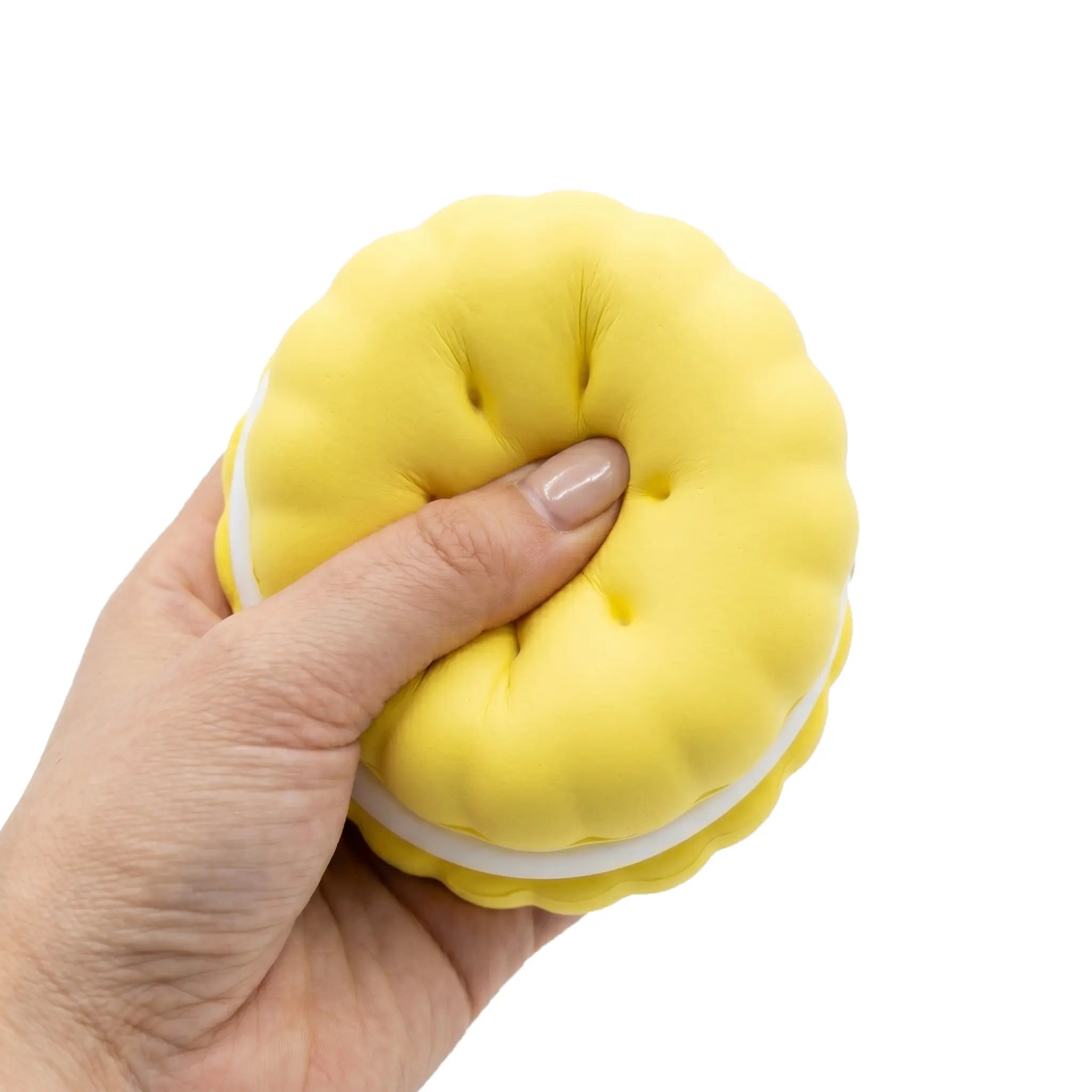 Yellow macaron squishy toy being pressed and squeezed on white background by MimiSquishy