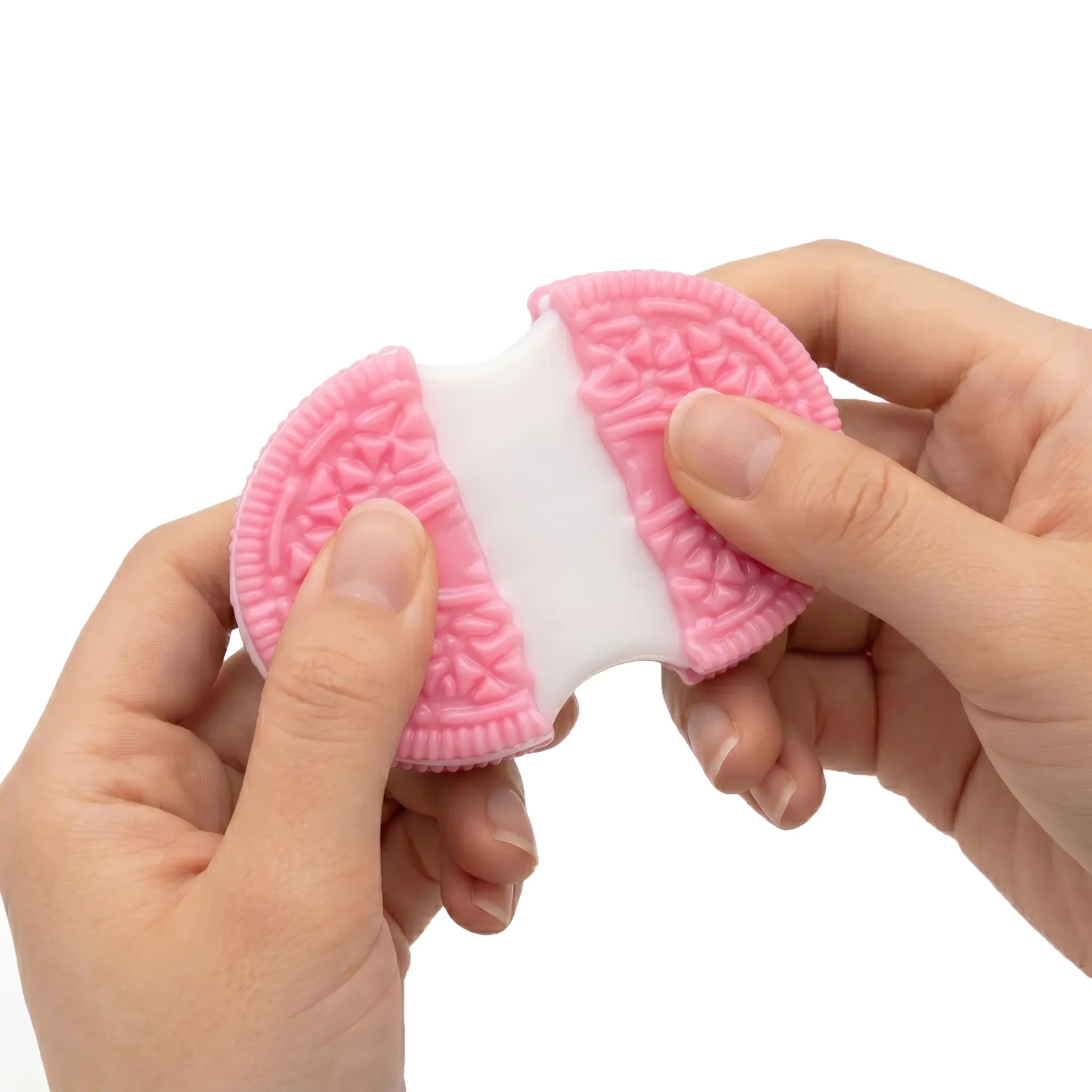 Hands squeezing a soft sticky pink cookie squishy toy by MimiSquishy